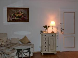 ein Wohnzimmer mit einer Couch und einem Tisch mit einer Lampe in der Unterkunft Alpenflair Ferienwohnungen Whg 214 "Schanzenblick" in Oberstdorf