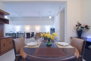 a dining room table with a vase of flowers on it at Perch Arbor-Golf Course Road in Gurgaon