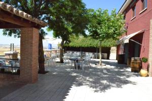 a patio area with tables, chairs, and a building at La Posada de Rosa in Hita
