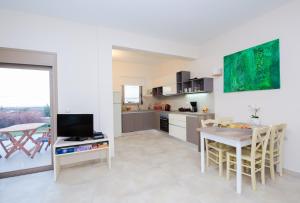 a kitchen and dining room with a table and a television at Mon Emvasia Margarites Villas in Margarítai