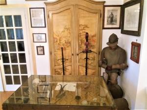 Una estatua de un hombre parado frente a una puerta de madera. en Villa Maria Sole, en Revello