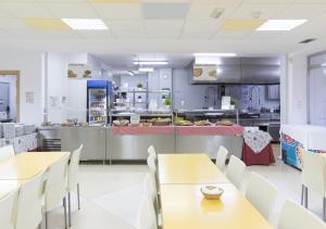 a restaurant with tables and chairs and a kitchen at Albergue Inturjoven Torremolinos in Torremolinos