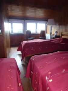 アゴン・クタンヴィルにあるLe Petit Closのベッドルーム1室(赤いシーツと窓付きのベッド2台付)