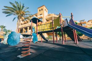 a playground with a slide in front of a building at Grand Muthu Golf Plaza Hotel & Spa in San Miguel de Abona