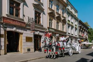 a horse drawn carriage on a city street at Orlowska Townhouse Apartments in Kraków