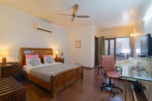 a bedroom with a bed and a desk and a chair at Perch Arbor Suites in Gurgaon