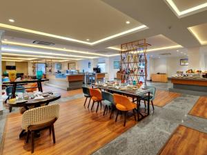 comedor con mesas y sillas y cocina en Amanora The Fern Hotels & Club en Pune