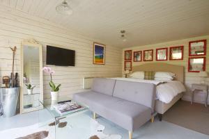 a bedroom with a bed and a couch and a tv at The Wheatsheaf Combe Hay in Bath