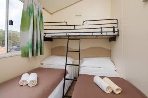 2 łóżka piętrowe w pokoju z oknem w obiekcie Private Bay Residence w mieście Vrboska