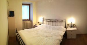 ディマーロにあるMarmot Apartmentのベッドルーム1室(白いシーツ付きのベッド1台、窓付)