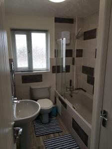 a bathroom with a sink and a toilet and a tub at Columbine, Thetford, 2BR House in Thetford