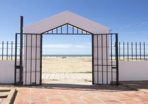 una puerta abierta en la playa con la playa de fondo en Albergue Inturjoven Punta Umbría, en Punta Umbría