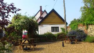 a house with two benches in front of it at The Griffin Hotel in Attleborough