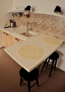 a kitchen with a counter and a sink and two stools at Studia Letců 2A in Olomouc