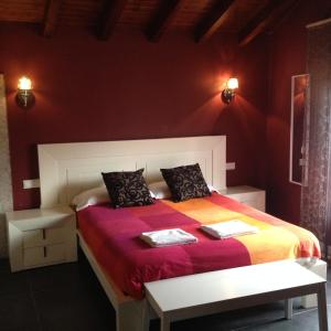 a bedroom with a bed with a red wall at Baelo Claudia in Navalguijo