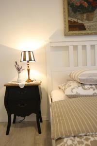 a bedroom with a bed and a table with a lamp at The 2Sisters Suite in Zadar