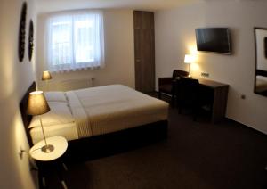 a hotel room with a bed and a desk at Studia Letců 2A in Olomouc