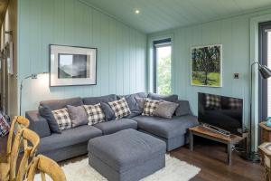 a living room with a couch and a tv at Aberdaron Lodge in Aberdaron