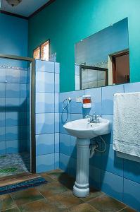 a blue bathroom with a sink and a mirror at Hostel Sunset Villas Popoyo in Popoyo