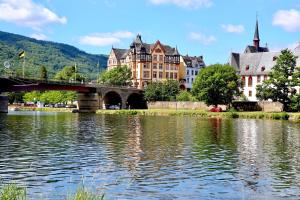 a bridge over a river in a city with buildings at Weingut Bastian in Brauneberg