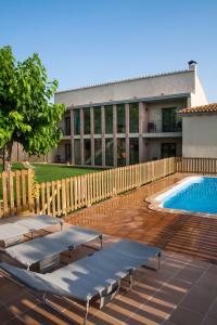 - une piscine avec 2 chaises longues à côté d'un bâtiment dans l'établissement Can 28, à Torroella de Montgrí