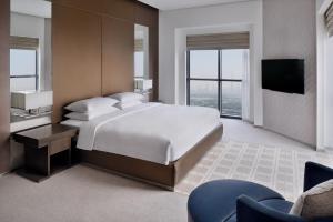 a bedroom with a large bed and a television at Hyatt Regency Creek Heights Residences in Dubai