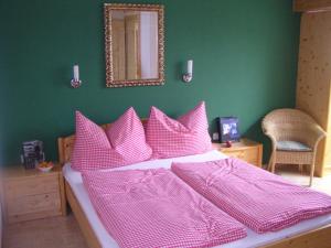 a bedroom with a bed with pink sheets and a mirror at Haus H.O.F. in Ramsau am Dachstein