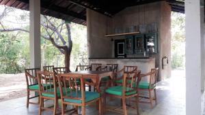 einen Holztisch und Stühle auf einer Terrasse in der Unterkunft Rangiri Dambulla Resort in Dambulla