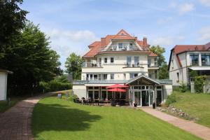 a large white house with a lawn in front of it at Hotel Villa Passion in Malchow