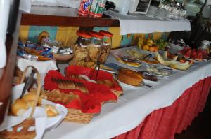une table sous forme de buffet avec de nombreux types de nourriture différents dans l'établissement Pousada Porta Do Céu, à Búzios
