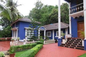 a blue house with a group of benches in front of it at The Pereira's Goan Homestay Villa in Vasco Da Gama