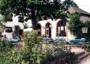 a house with people sitting at tables in a garden at Appartement Schepper's in Trier