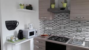 a kitchen with a stove and a microwave at Bolognamania Apartments-Prime in Bologna