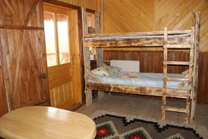 ミホヴォにあるSkhovanka Dovbushaの木造キャビン内の二段ベッド2台が備わる客室です。