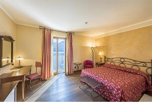 a bedroom with a bed and a desk and a window at La Darsena Boutique Hotel & Restaurant in Tremezzo +88 photos