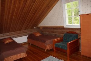 a bedroom with a bed and a chair and a window at Nukula Guestrooms in Oravasaari +23 photos