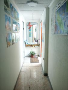 a hallway with a tile floor in a room with pictures at Hostel Room Aruba in Oranjestad