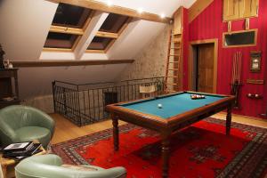 een woonkamer met een pooltafel op een rood tapijt bij Le Manoir in Chaumont