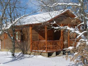 domek z bali z werandą w śniegu w obiekcie Camping Riaza w mieście Riaza