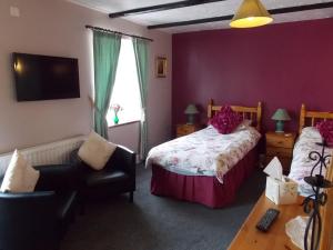 um quarto com uma cama, uma cadeira e uma janela em The Fountain Inn em Parkend