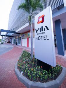 a sign for a hotel in front of a building at Vila Business Hotel in Volta Redonda