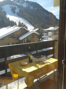 a table with a bottle of wine on a balcony at Studio Chatel in Châtel