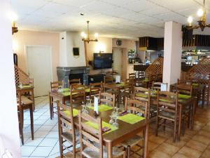 uma sala de jantar com mesas e cadeiras de madeira em Hôtel Restaurant du Pont-Vieux em Saint-Flour