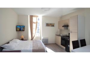 ニュイ・サン・ジョルジュにあるGites du Beffroiの小さなベッドルーム(ベッド1台付)、キッチンが備わります。