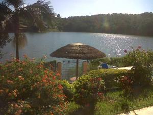 een tafel met een paraplu naast een meer bij Recanto Bela Vista in Caconde