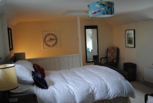 a bedroom with a white bed and a clock on the wall at The Old Reading Room in Kingston