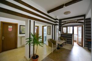 - un hall avec une table, des chaises et une plante dans l'établissement Hotel Paraul Capra, à Cumpăna