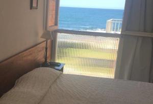 a bedroom with a bed and a view of the ocean at Perla del Este in La Paloma +22 photos