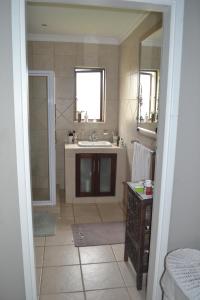 a bathroom with a sink and a mirror at Claire's Deluxe Studio Apartment - SOLAR in Ballito