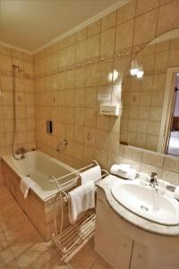 a bathroom with a tub and a sink and a mirror at Logis Hôtel-restaurant La Mère Biquette in Saint-Pons +55 photos